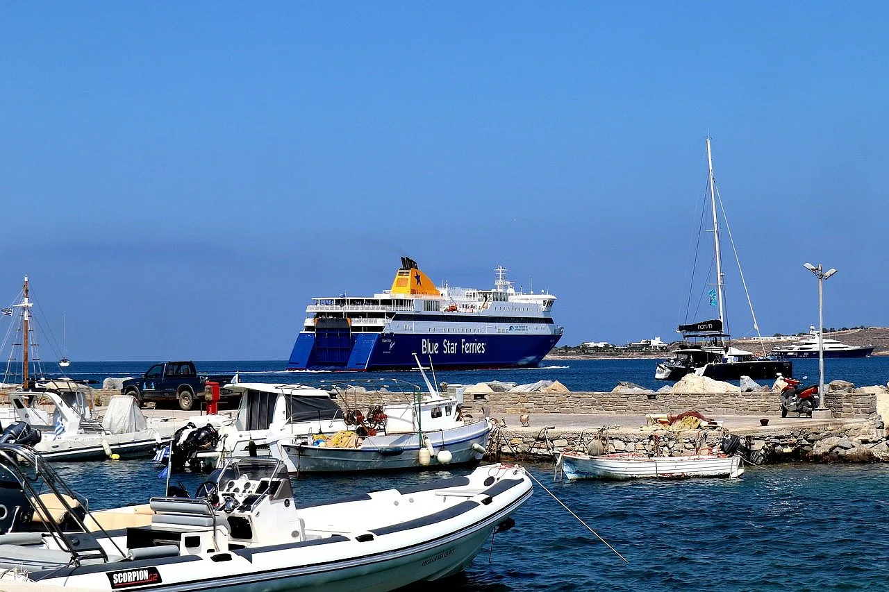 port w paros z wieloma łódkami i wielki statek w tle, ciemnoniebieskie niebo