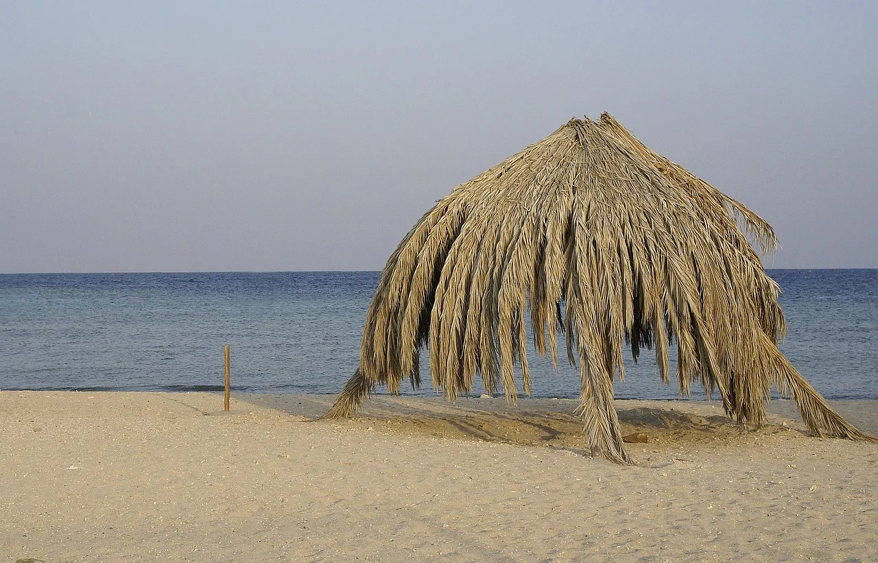 plaża i nietypowy parasol z ususzonych liści palmy