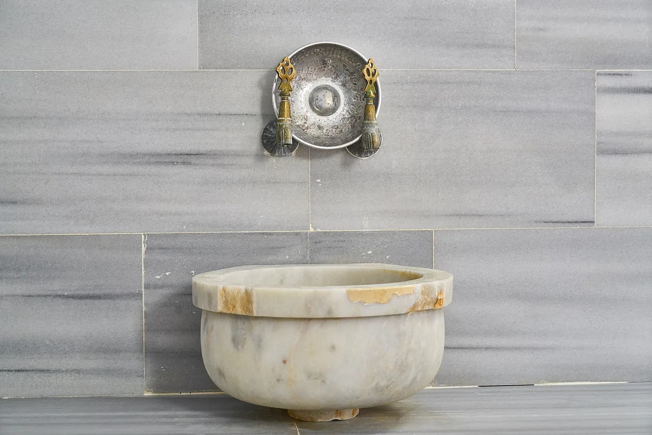Tradycyjna ottomańska łaźnia z marmurową fontanną i ceramicznymi detalami w historycznym spa w Turcji.