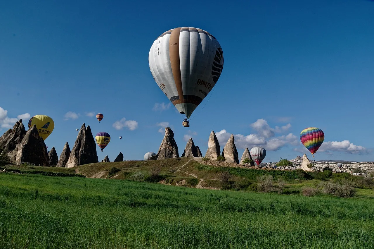 Balony na gorące powietrze unoszące się nad skalnym krajobrazem Kapadocji w Turcji