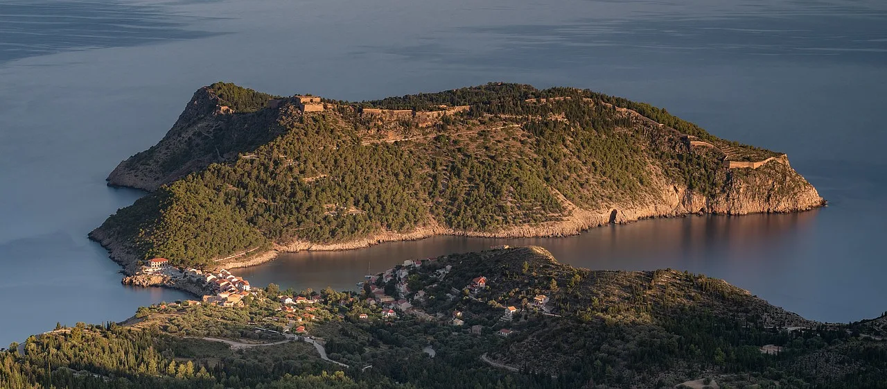 wyspa kefalonia pokryta drzewami oraz oświetlona zachodzącym słońcem