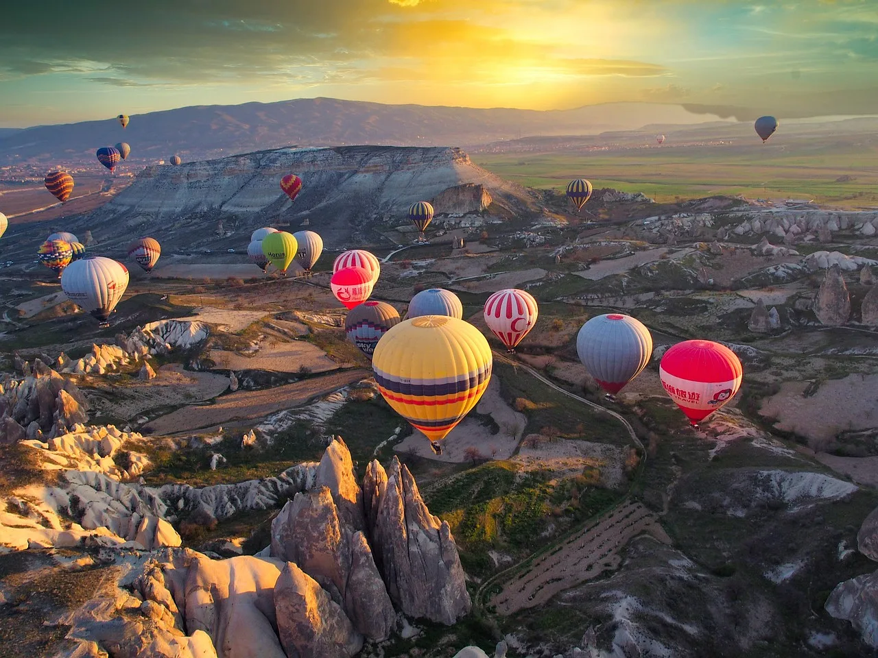 Balony unoszące się nad doliną w Kapadocji o zachodzie słońca
