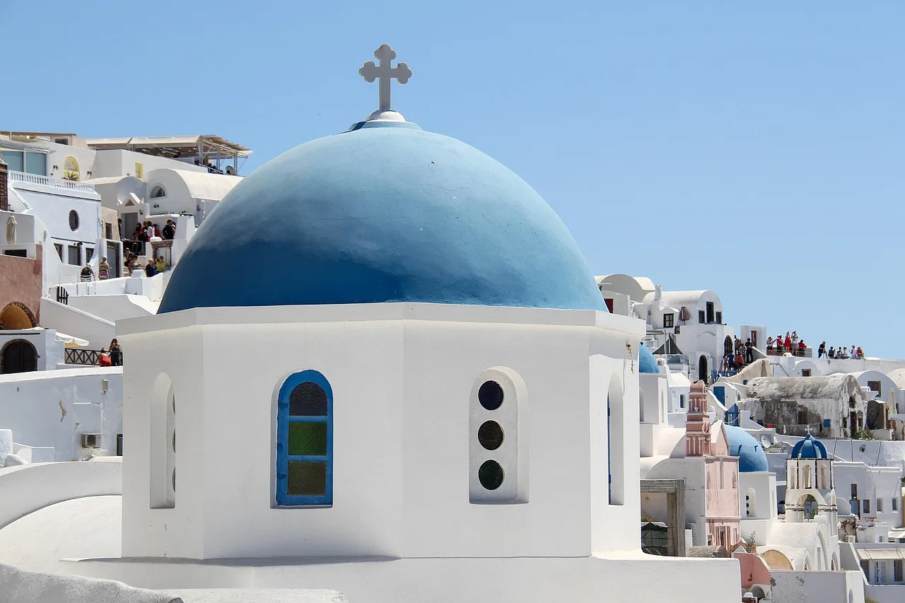 Biały kościół z niebieską kopułą w Oia, Santorini, Grecja