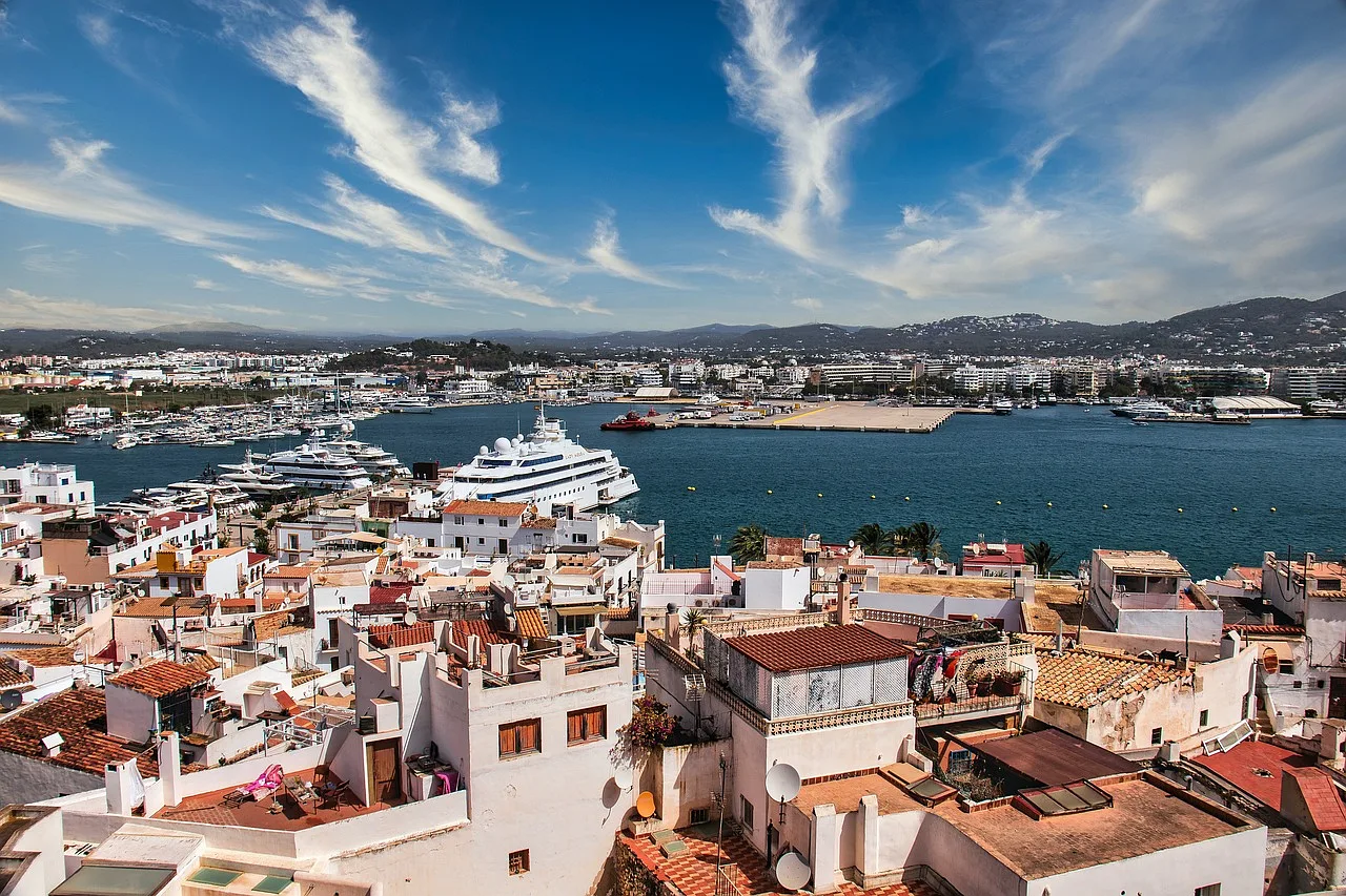 Widok na port w Ibizie, Hiszpania, z licznymi jachtami i malowniczym krajobrazem miasta
