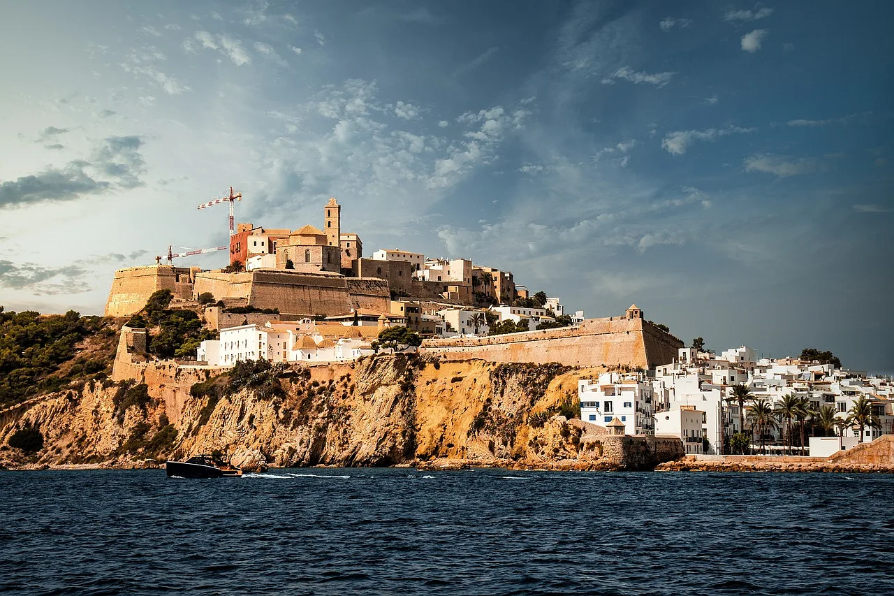 Widok na miasto na wyspie Ibiza, Hiszpania, z imponującymi budowlami na klifie i błękitnym morzem