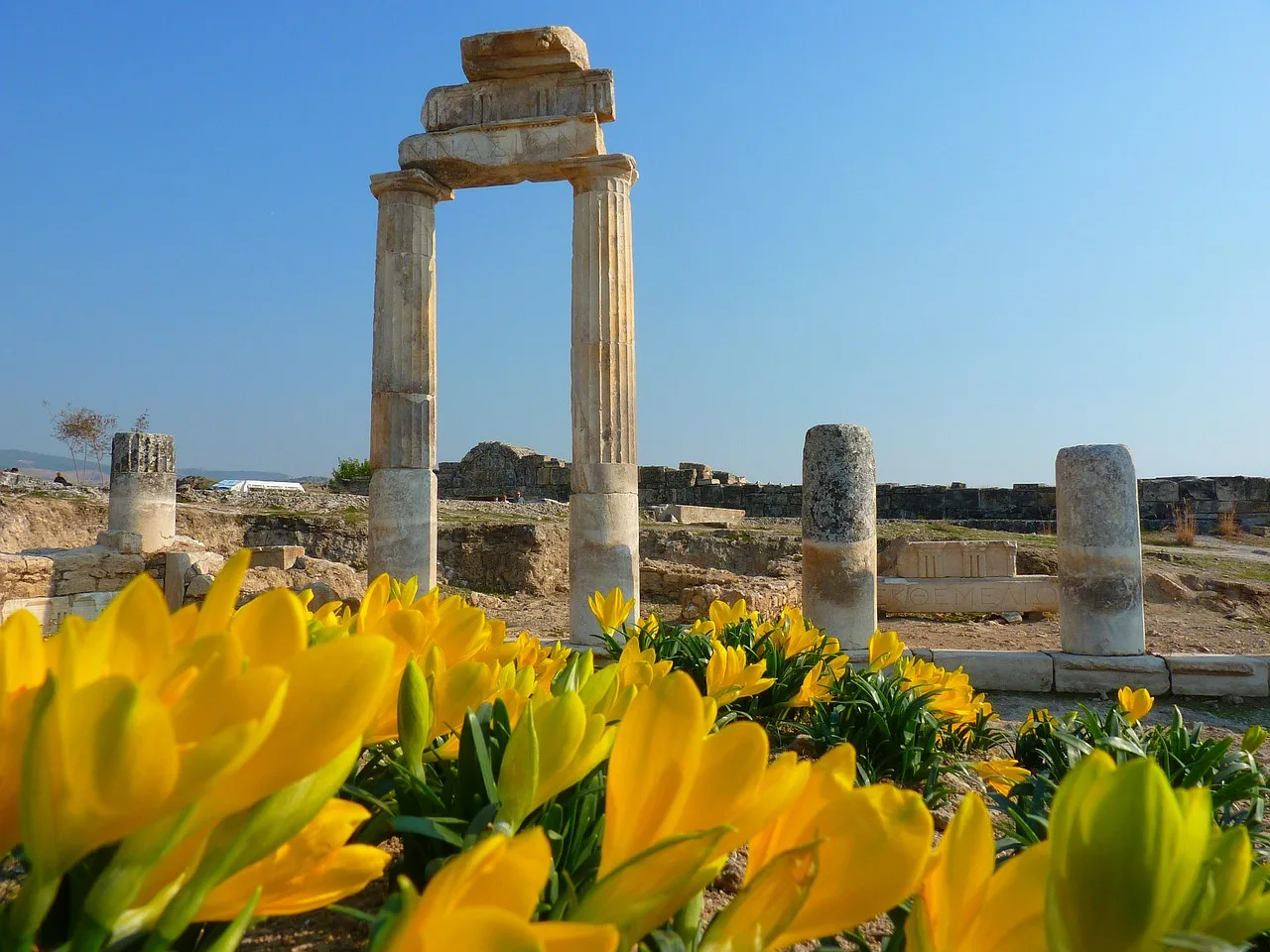 Ruiny starożytnego miasta Hierapolis w Pamukkale, Turcja, z widokiem na pozostałości w okolicach tarasów travertynowych.
