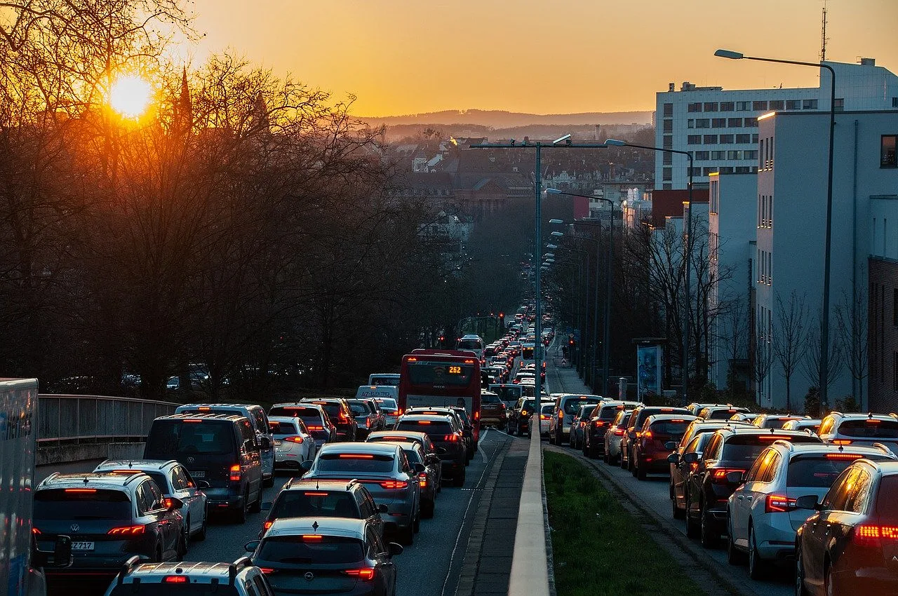 Zatłoczony ruch uliczny w mieście o poranku podczas zachodu słońca.