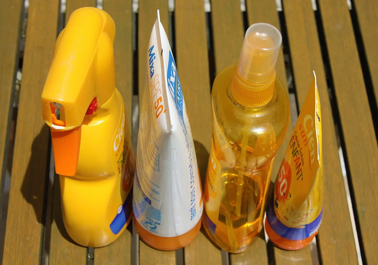 Butelka kremu do opalania na plaży, gotowa do użycia w letnim słońcu.